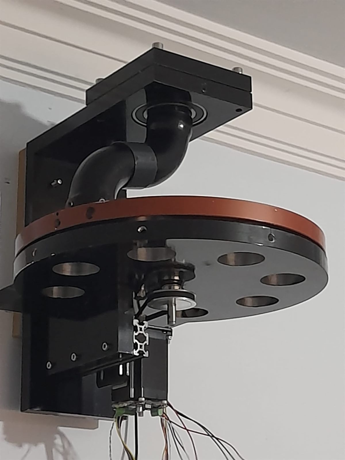 Ceiling-mounted rotary bean distributor with six outlet ports and a copper accent ring