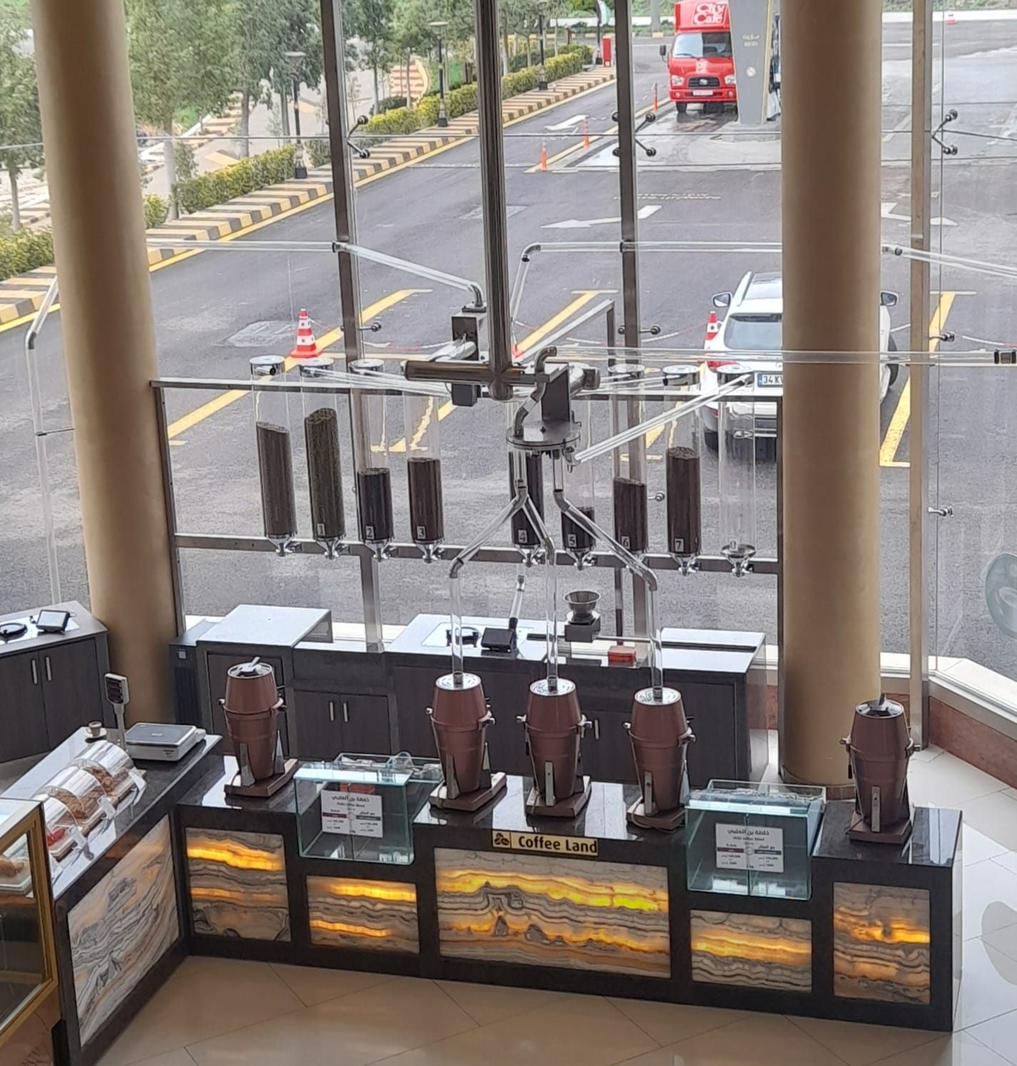 Coffee Land retail counter with eight numbered bean silos fed by overhead acrylic pipes